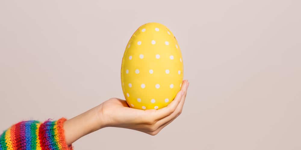 Hand Holding a Patterned Yellow Egg