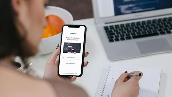 Woman Holding iPhone X and Taking Notes