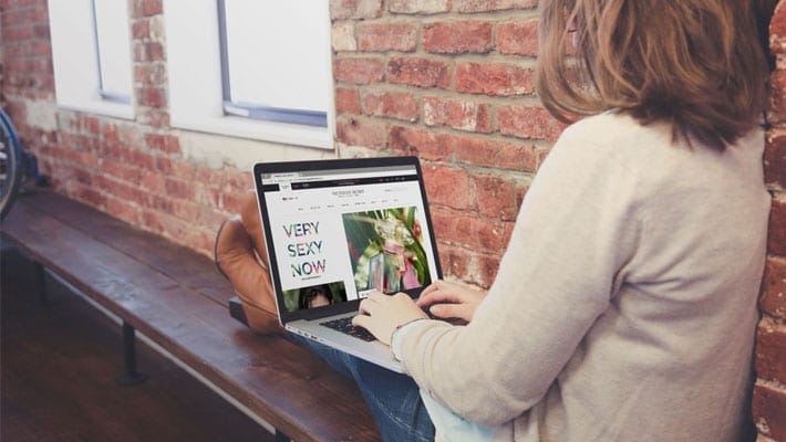 Woman Sitting with Macbook on her knees