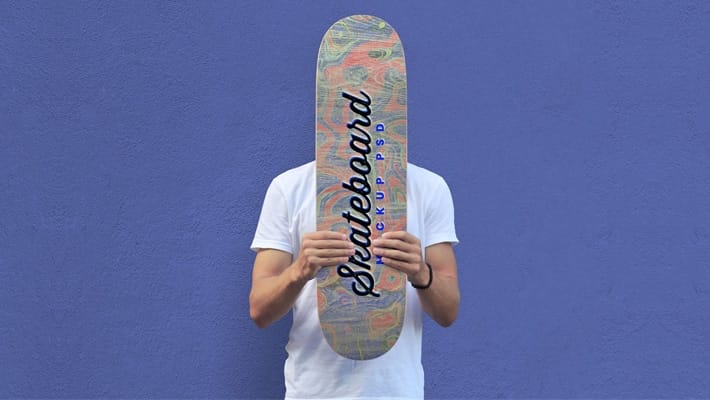 Free Man Holding Skateboard Mockup PSD