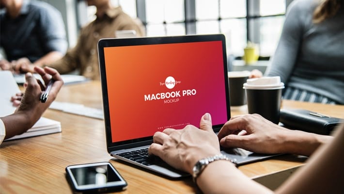 Free Person Using MacBook Pro Mockup PSD
