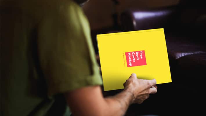Free Book in a Country Mans Hand Mockup