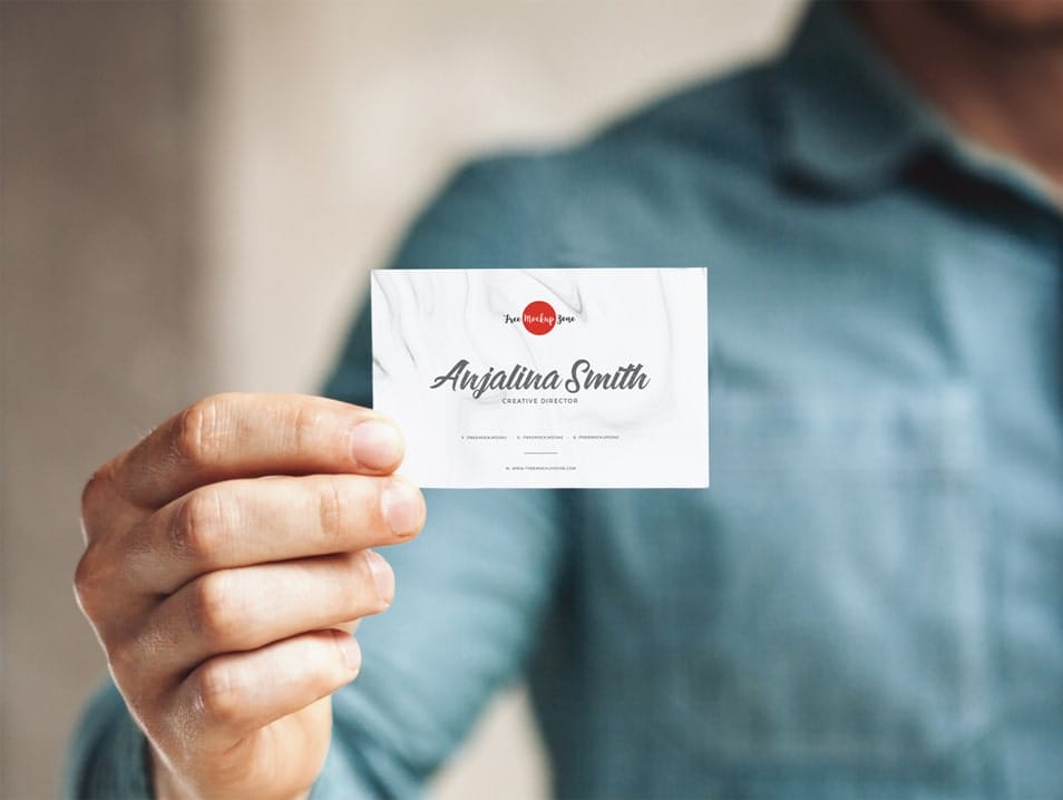 Free Man Holding in Hand Business Card Mockup PSD