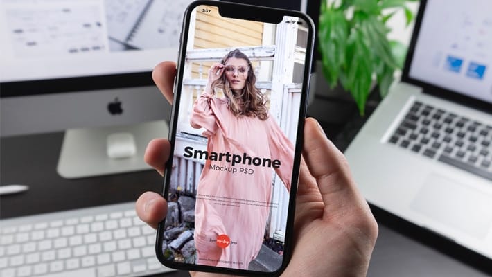 Free Man Holding Smartphone Mockup PSD