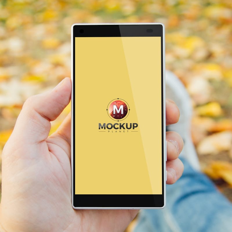 Free Man in Park Holding Smartphone Mockup