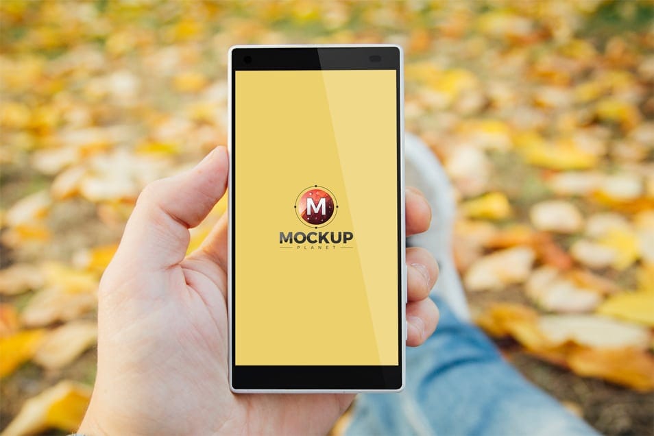 Free Man in Park Holding Smartphone Mockup
