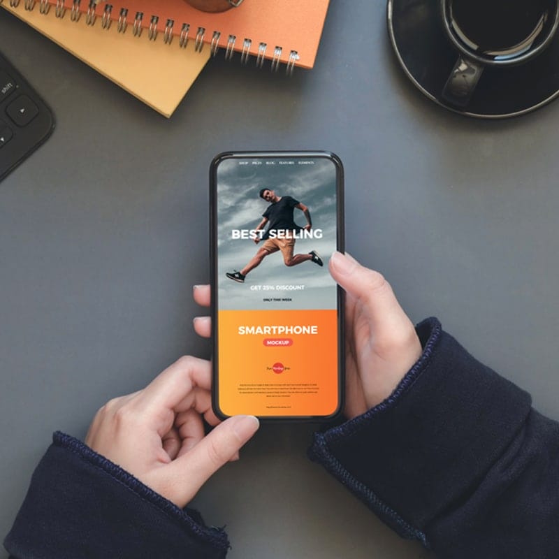 Free Workstation Person Holding Smartphone Mockup