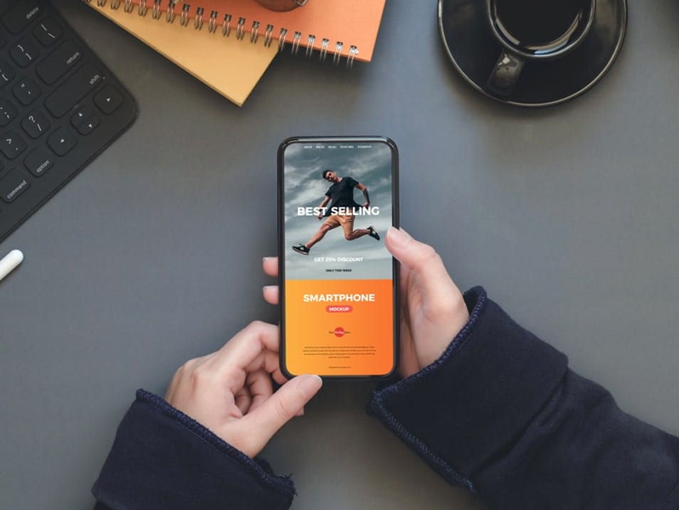 Free Workstation Person Holding Smartphone Mockup