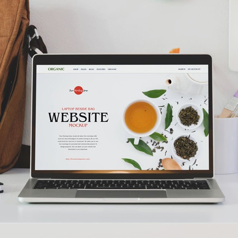 Free Laptop Beside Bag Website Mockup