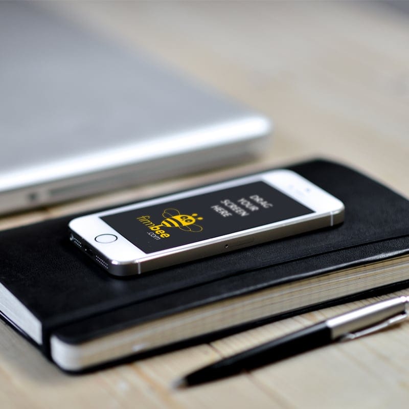 Apple iPhone 5 Lying on a Notebook PSD Mockup