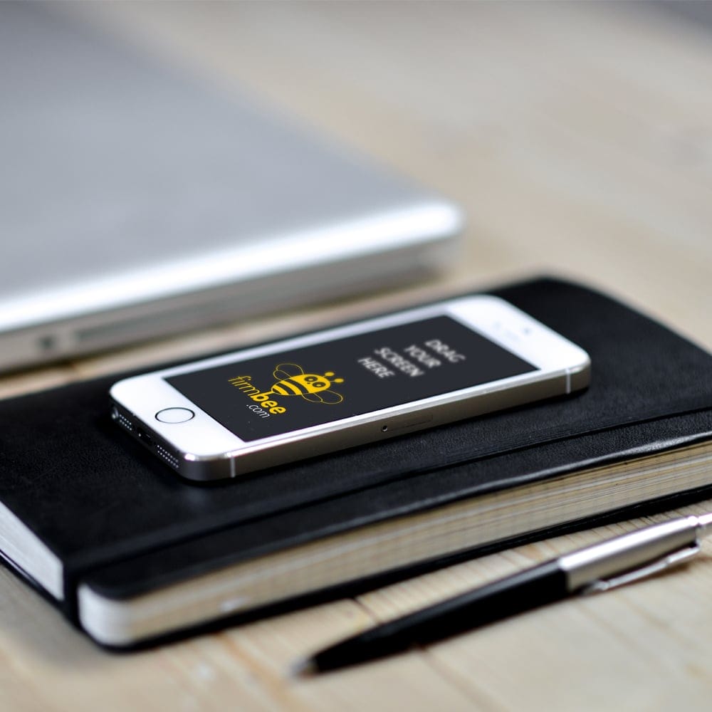 Apple iPhone 5 Lying on a Notebook PSD Mockup