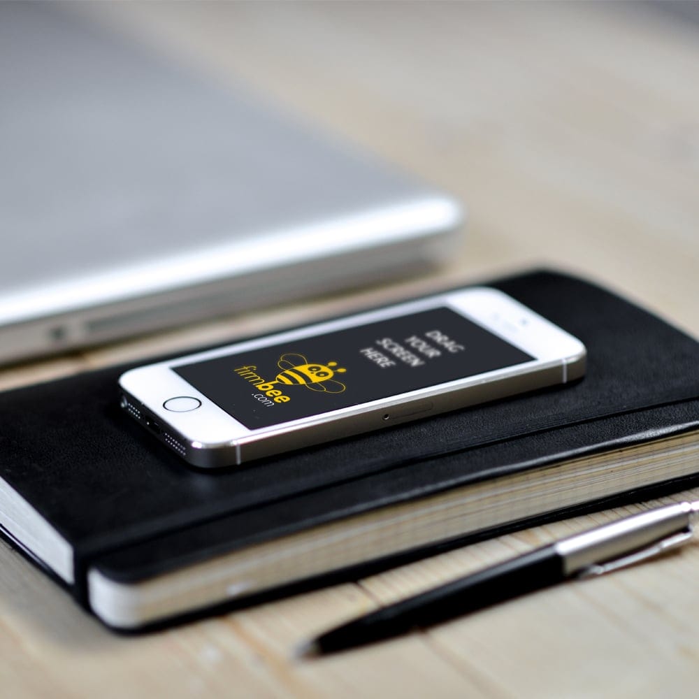 Apple iPhone 5 Lying on a Notebook PSD Mockup