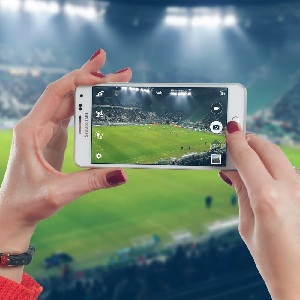 Woman Uses Mobile On The Football Stadium Free Mockup PSD