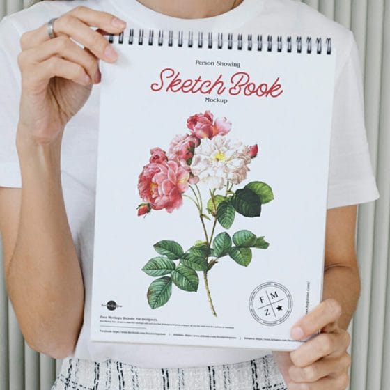 Free Person Showing Sketch Book Mockup