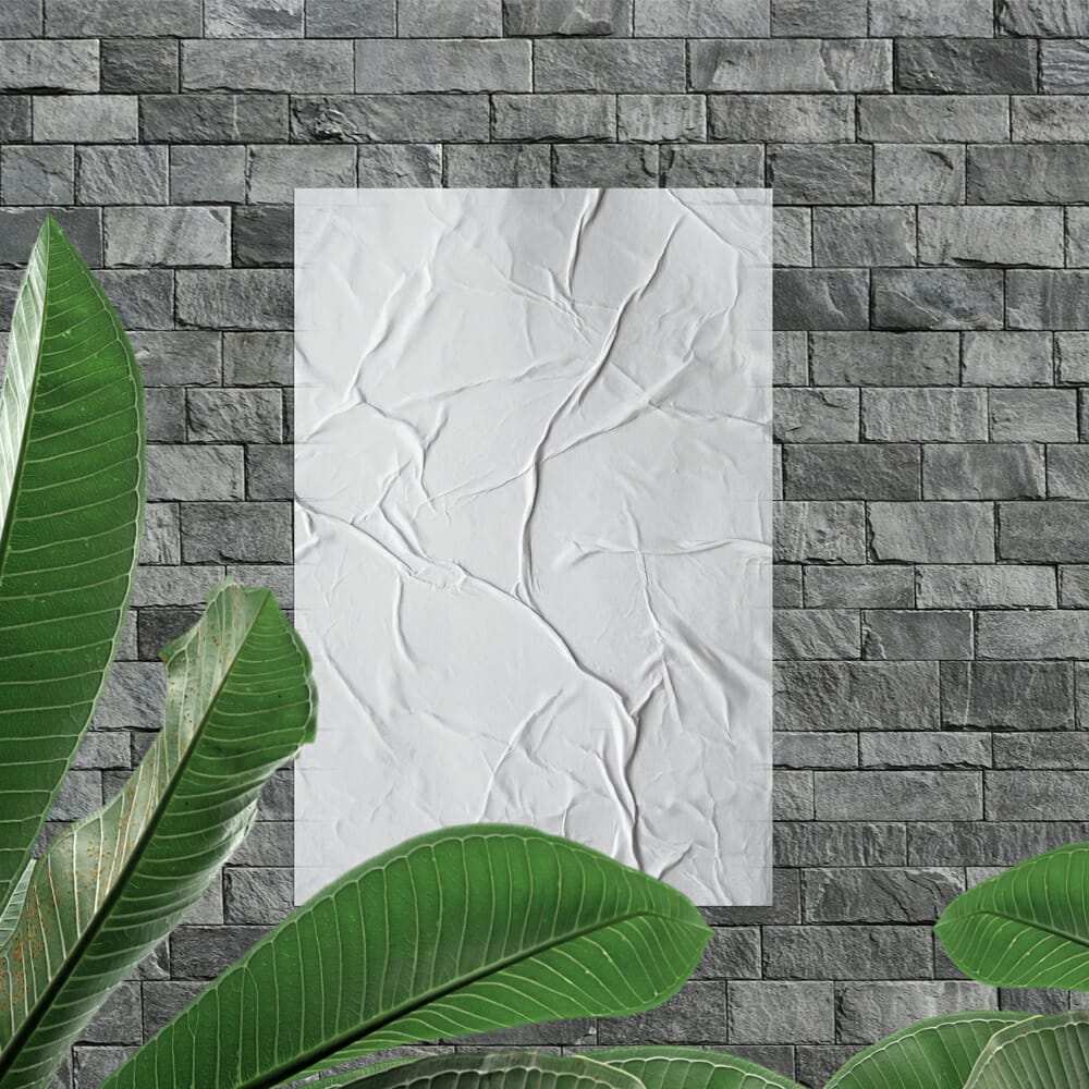 Glued Poster on Stone Wall Mockup With Leaves