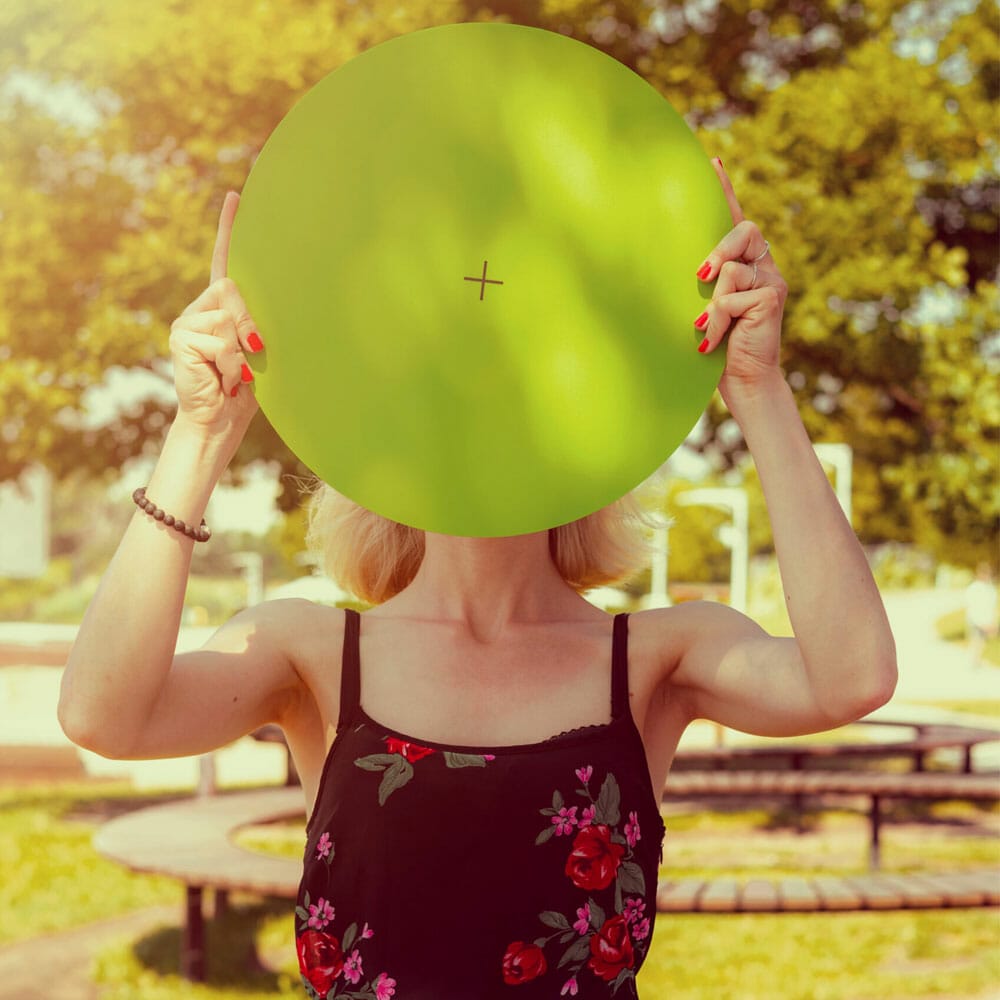 A Woman Holding A Round Banner In The Park Free Mockup