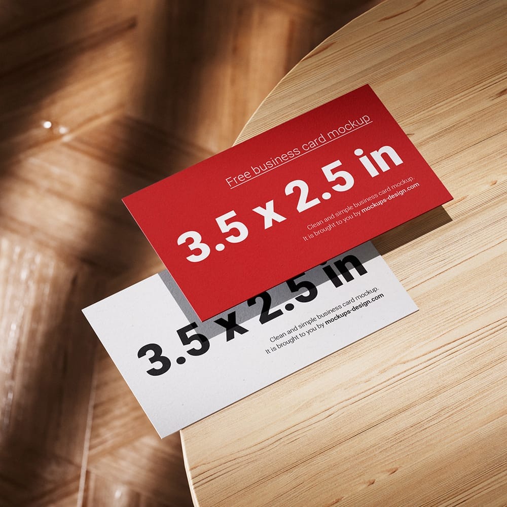 Free Business Cards Lying on a Wooden Table Mockup PSD