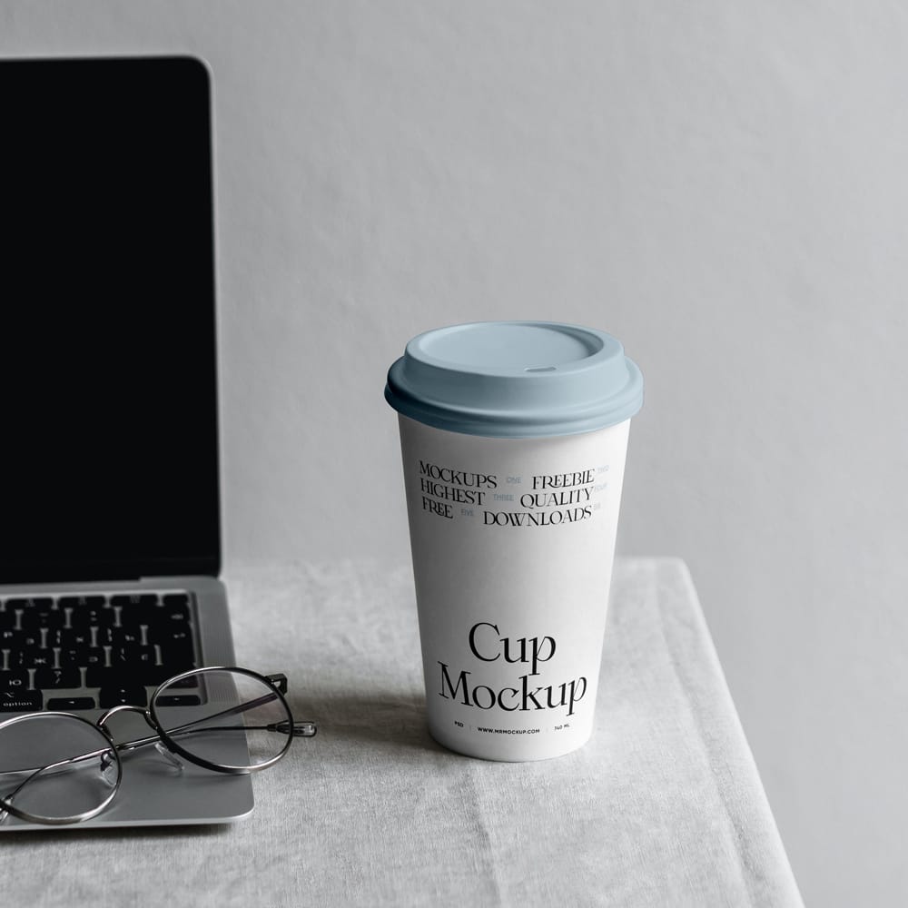Free Paper Coffee Cup with MacBook Mockup PSD