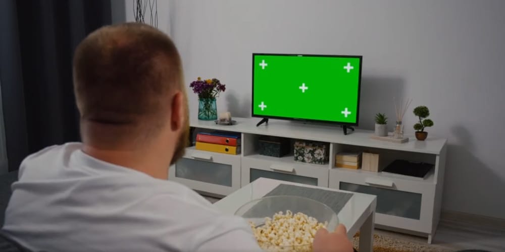 Man Watches Green Mock-up Screen TV