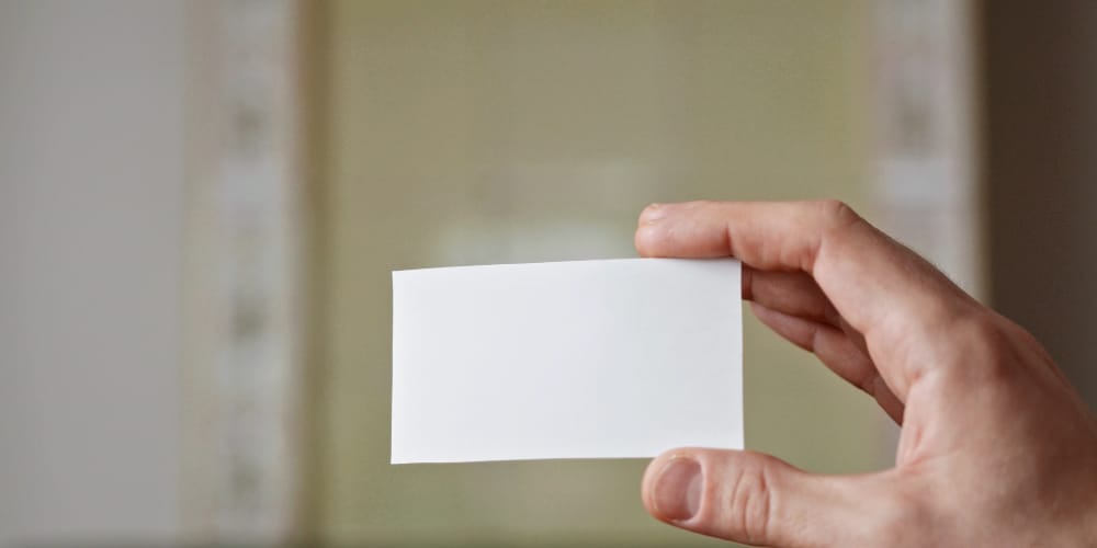 Person Holding A Piece Of White Blank Card