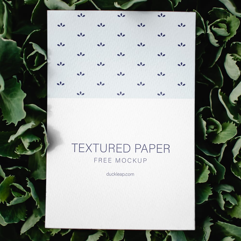 Free Textured Paper on Green Leaves Mockup PSD