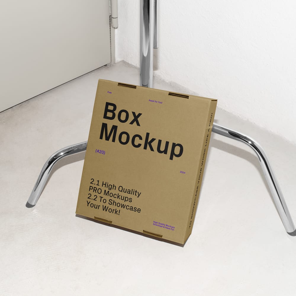 Free Cardboard Box Leaning Against the Tripod Mockup PSD