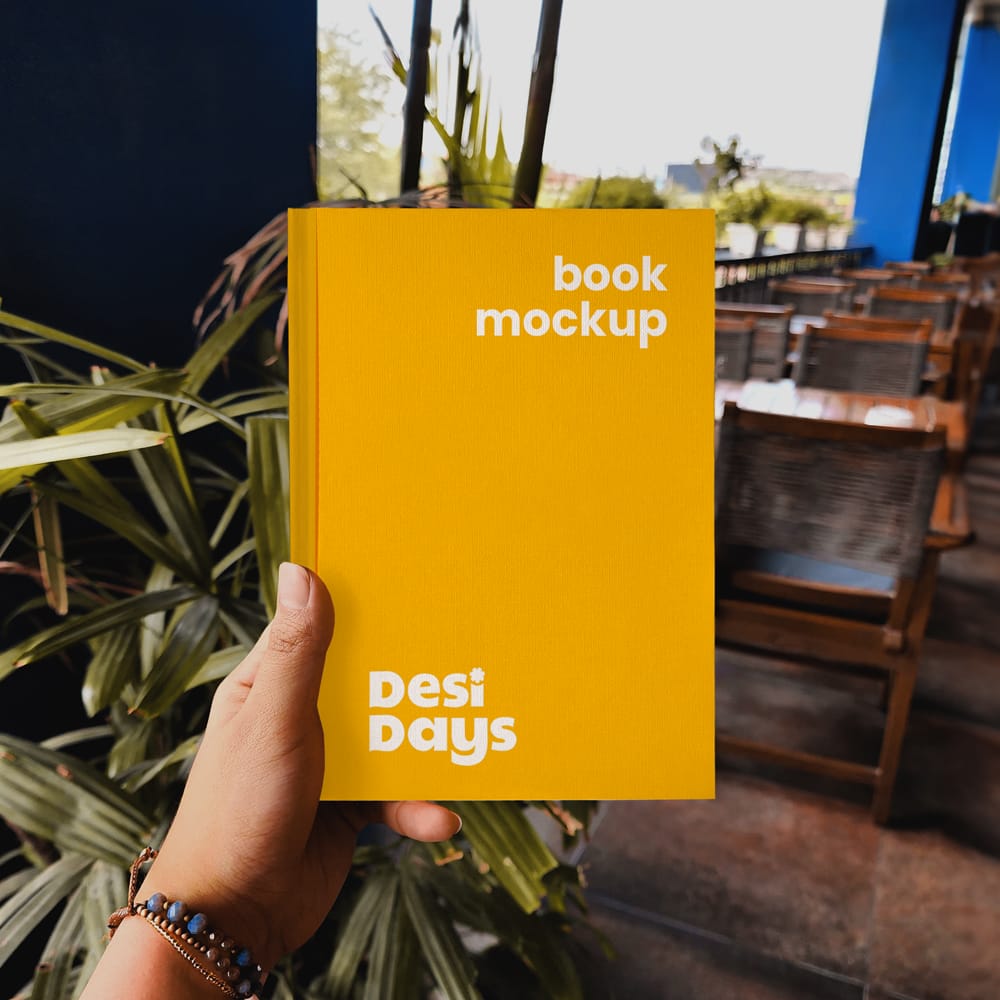 Free Hand Holding a Book Mockup PSD