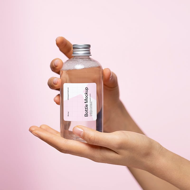 Transparent Glass Bottle Mockup in Hands PSD